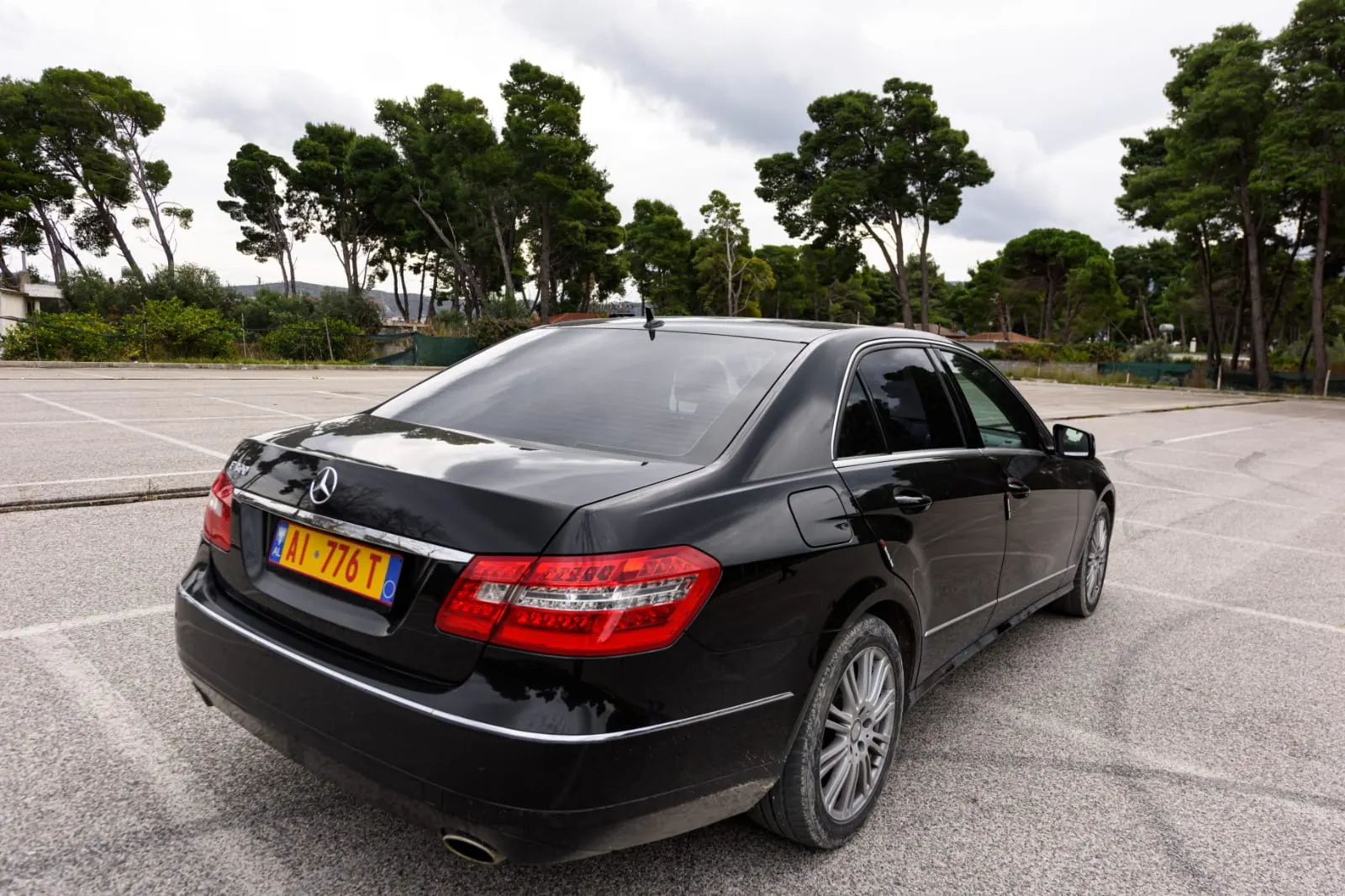 Rear three-quarter view of the black Mercedes-Benz E-Class used by Dhermi Taxi