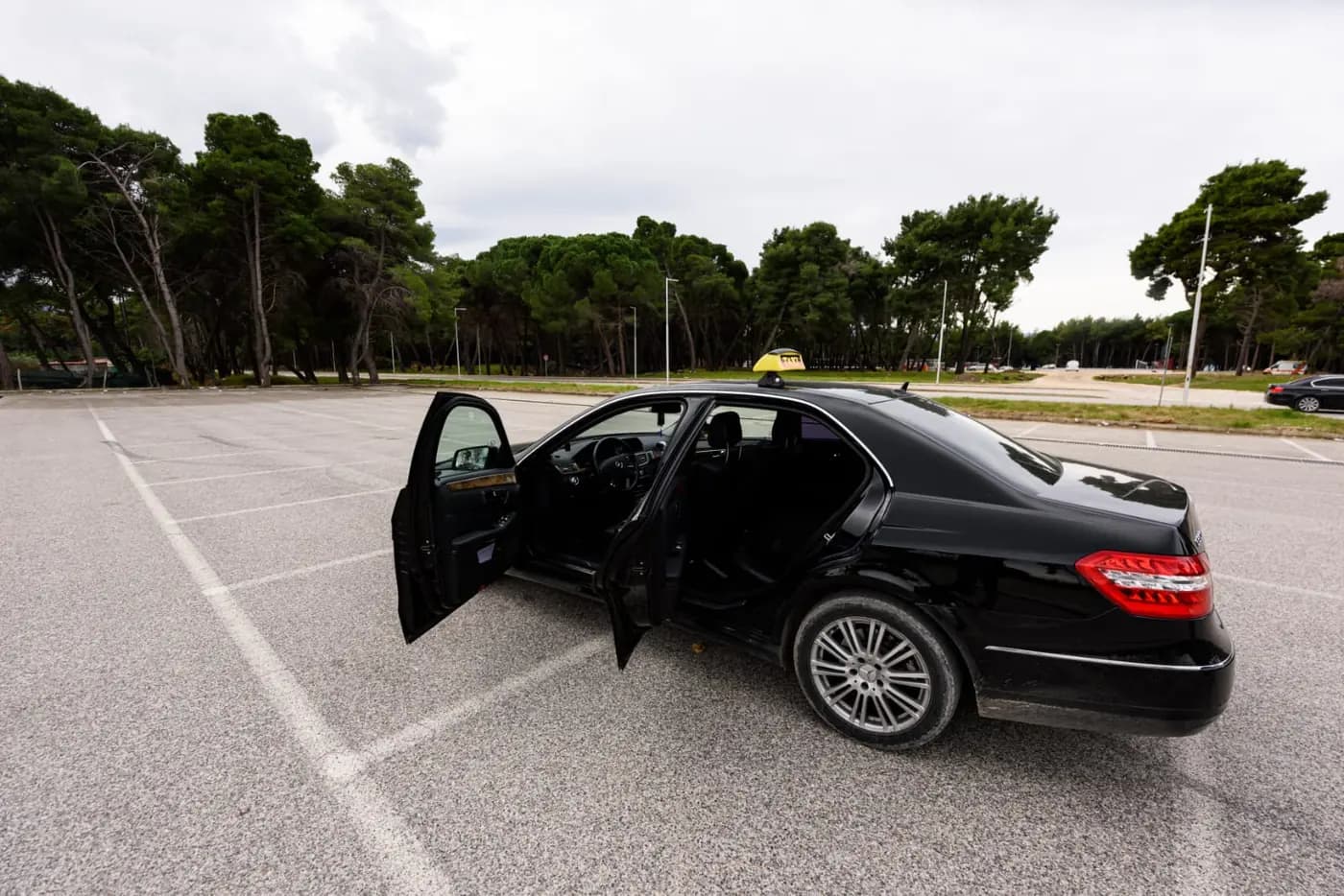 The Mercedes-Benz E-Class taxi with its doors open, seen from the rear